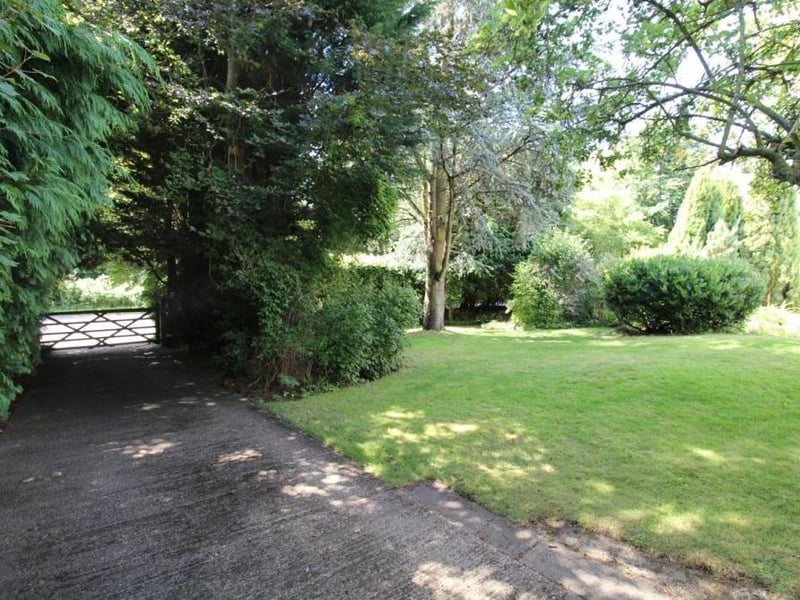 Gates that open on to one of two driveways leading to the four-bedroom house.
