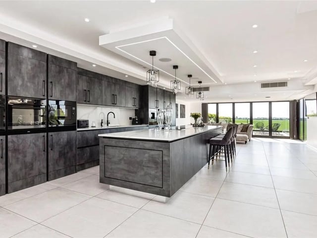 The kitchen features sleek cabinetry, premium integrated appliances, and a generous central island create a space that’s as functional as it is stylish.