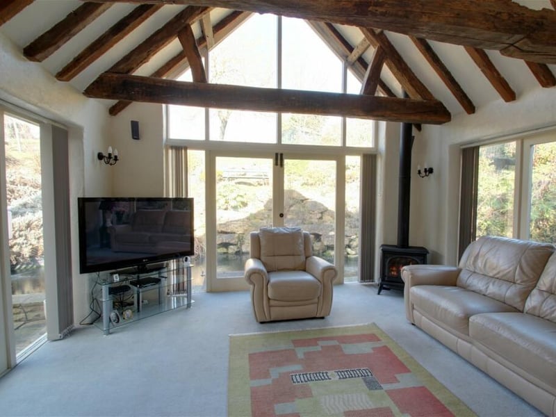 Bright and airy, the incredible garden room is flooded with natural light thanks to double doors to three sides. Exposed beams to the apex give a feel of vintage character, while a gas burning stove provides the warm finishing touch.