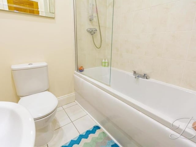 The family bathroom at the £475,000 barn conversion looks like this. It comprises a panelled bath with overhead shower, low-flush WC, wash hand basin and tiled flooring.