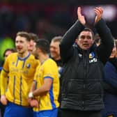 Nigel Clough applauds fans on the pitch after the FA Cup fourth round football match between Burnley and Mansfield Town at Turf Moor in Burnley on February 14, 2026. (Photo by Paul Currie / AFP via Getty Images)