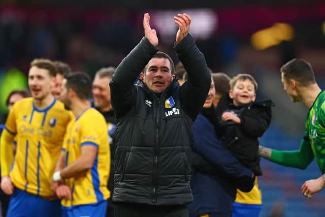 Nigel Clough applauds fans on the pitch after the FA Cup fourth round football match between Burnley and Mansfield Town at Turf Moor in Burnley on February 14, 2026. (Photo by Paul Currie / AFP via Getty Images)