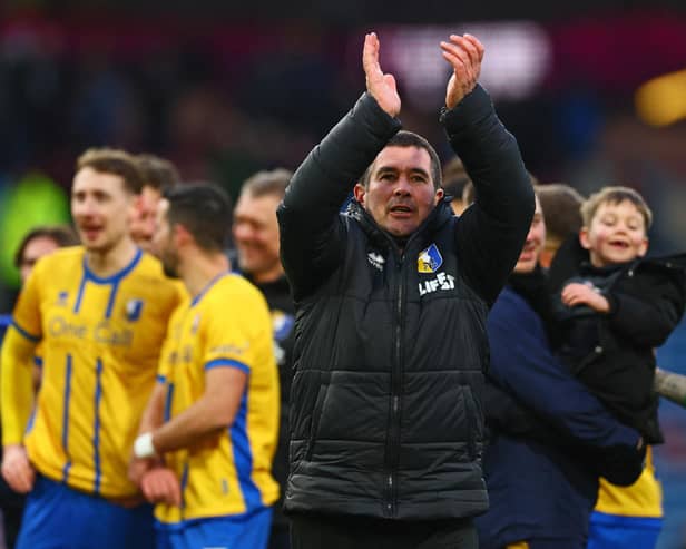 Nigel Clough applauds fans on the pitch after the FA Cup fourth round football match between Burnley and Mansfield Town at Turf Moor in Burnley on February 14, 2026. (Photo by Paul Currie / AFP via Getty Images)