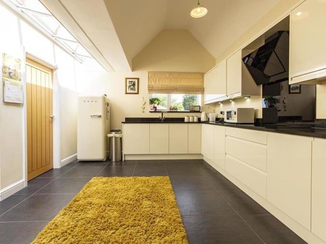 Integrated appliances in the kitchen include a freezer, dishwasher, electric double oven and induction hob, with angled extractor over. There is a one-and-a-half-bowl stainless steel sink with mixer tap, a tiled floor and space for a fridge. Through an oak internal door is a utility room, where there is space and plumbing for a washing machine and tumble dryer.