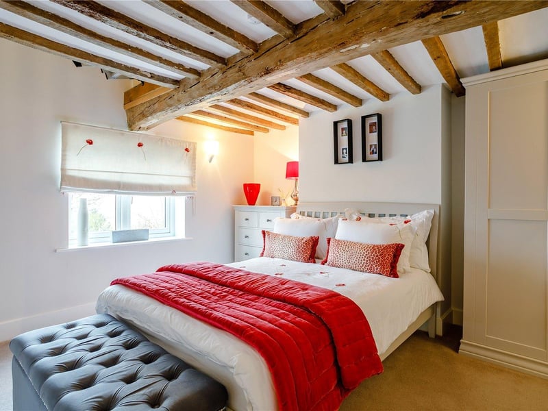 The second bedroom features original, exposed beams.