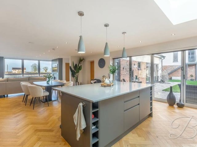 A shot that underlines how bright and spacious the kitchen is. Bi-folding doors lead out to the garden and, in the background, you can see there is ample room for a dining table.
