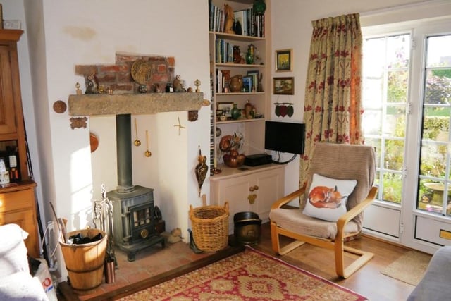 Another notable feature of the cosy lounge is this inglenook fireplace with its tiled hearth and cast-iron, muilti-fuel burner stove with glass door in the chimney.
