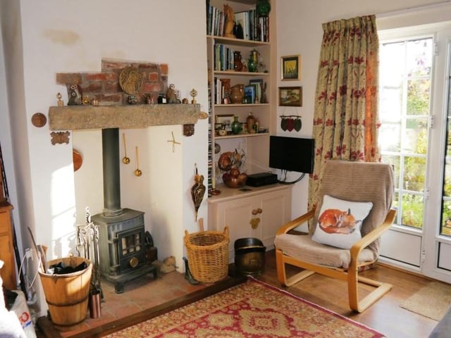 Another notable feature of the cosy lounge is this inglenook fireplace with its tiled hearth and cast-iron, muilti-fuel burner stove with glass door in the chimney.