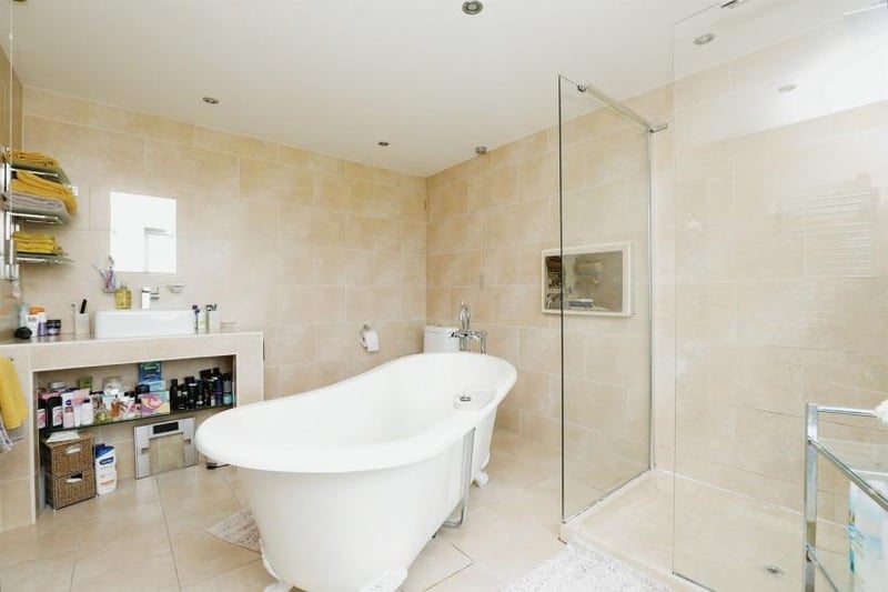 One of the luxurious bathrooms to be found at the £2 million property. It is distinguished by a central roll-top bath and a double walk-in shower.