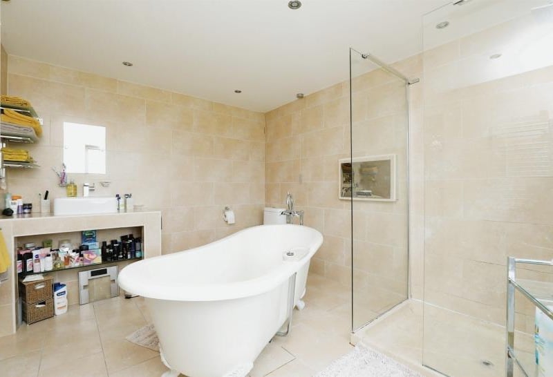 One of the luxurious bathrooms to be found at the £2 million property. It is distinguished by a central roll-top bath and a double walk-in shower.