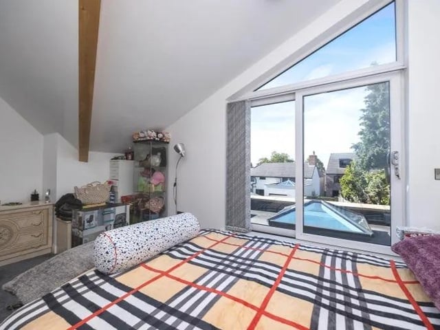 The staircase leads to the master bedroom, which is distinguished by its sliding doors that lead to a rooftop balcony overlooking the back garden.