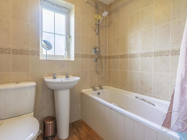 The main bathroom can be found in the centre of the first floor. It is fitted with a three-piece suite, comprising panelled bath with overhead shower, pedestal sink, low-flush WC, full-height tiling in a neutral colour and an opaque window to the side of the house.