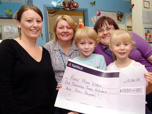 Cheque for £1,350 presented to the Robin Hood Ward at Kings Mill Hospital. Pictured (left to right) are: staff Michelle Budworth, Pauline Radford and Nicola Armstrong with patient Alex, and his sister Hannah. Year: 2007.