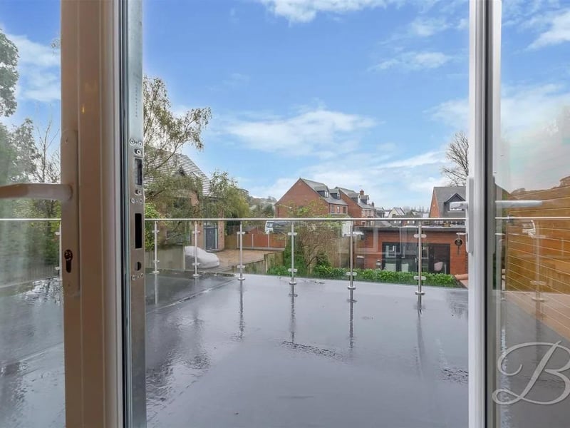The spacious balcony off bedroom 2 features views over the rear garden.