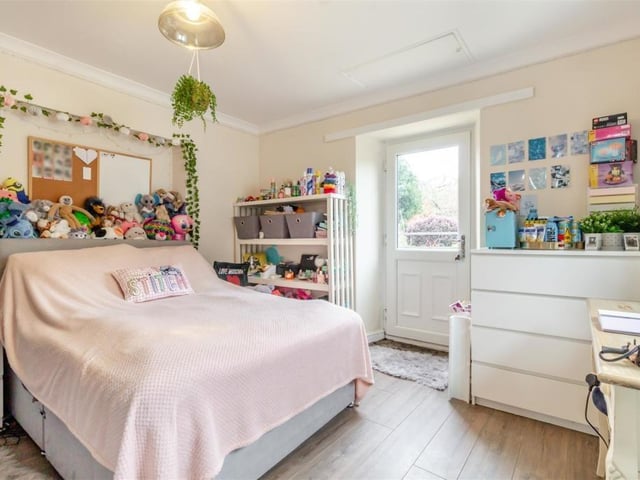 Unusually, this bright and busy bedroom has a uPVC double-glazed door leading out to the back garden. There is also a loft hatch and coving to the ceiling.