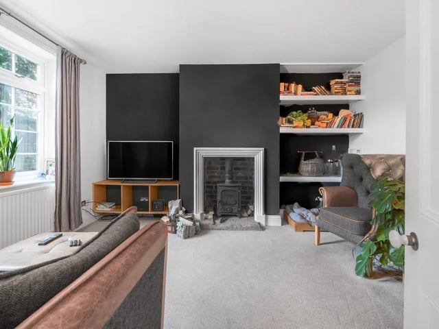 The spacious living room is adorned with tasteful décor and large windows that bathe the area in natural light.