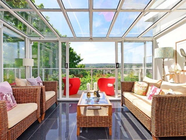 The conservatory leads onto a wraparound balcony with decking, glass, and beautiful views.