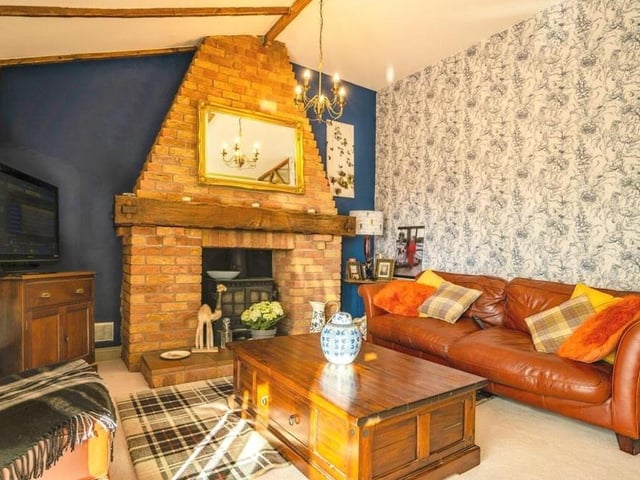 Let's begin our tour of the Selston bungalow in the cosy lounge, which is distinguished by an open, brick feature fireplace with multi-fuel log-burner.