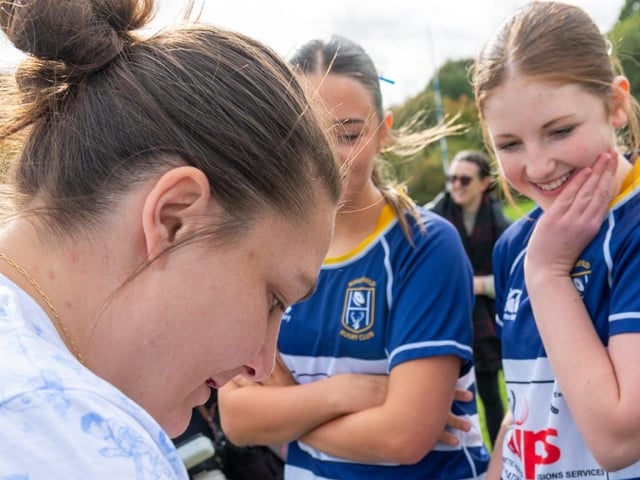 Amy Cokayne signing players boots.