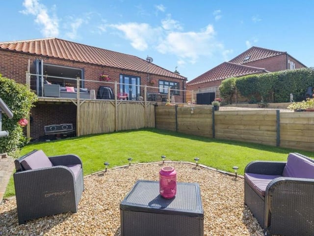 The lower-level garden at the £480,000 Forest Town bungalow includes this pleasant gravelled seating area. You can also spot storage space beneath the decking.