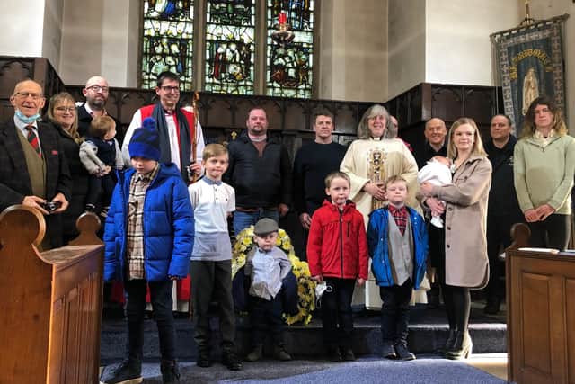 Former Rocking babies, including 90-year Brian Baxter (far left), line up at the church with the current baby and his mum, Georgia, plus the Bishop of Sherwood, the Rt Rev Andy Emerton, and the village vicar, the Rev Zoe Burton.