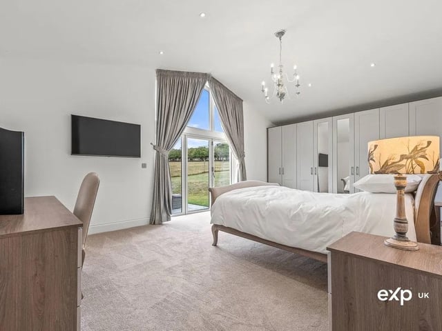 The principal bedroom suite is a peaceful haven. with magnificent bi-folding doors overlook the gardens to the rear and open out onto a patio. There is a full wall of fitted wardrobes providing useful storage. A vaulted ceiling with down lighting adds a soothing ambience, and the carpeted flooring benefits from underfloor heating. An en suite shower room adds a further touch of luxury.