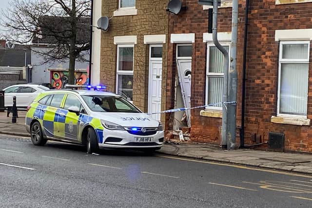 Police at the scene, with the damage to the house visible.