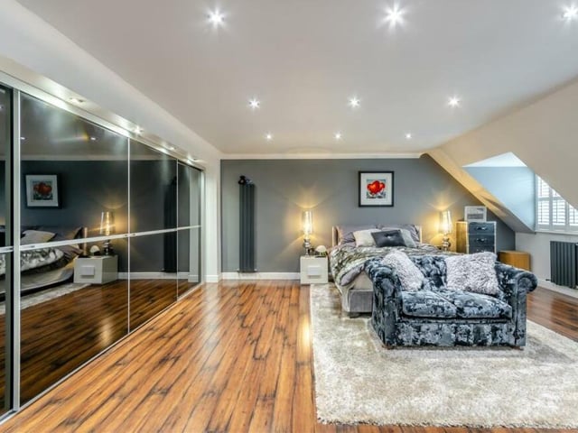 This second photo of the master bedroom shows, in all their glory, its extensive fitted wardrobes. They boast four sliding doors with five inset downlights above, operated by a dimmer switch, double hanging rails and access to eaves storage.