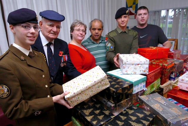Jo Austin of SOS (3rd left) is presented with Christmas boxes by l/r: Band Sgt Major Cassandra Mather, World War Two veteran Dennis Roberts, Tony Malthin(service user), Cpl Reece Atkins and Craig Wright(service user). Pictured at Milton Court, Doncaster in 2008