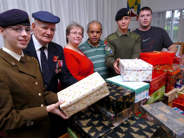 Jo Austin of SOS (3rd left) is presented with Christmas boxes by l/r: Band Sgt Major Cassandra Mather, World War Two veteran Dennis Roberts, Tony Malthin(service user), Cpl Reece Atkins and Craig Wright(service user). Pictured at Milton Court, Doncaster in 2008
