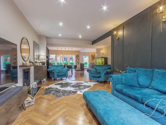 The living room is also distinguished by its feature panelled wall with fitted lighting.