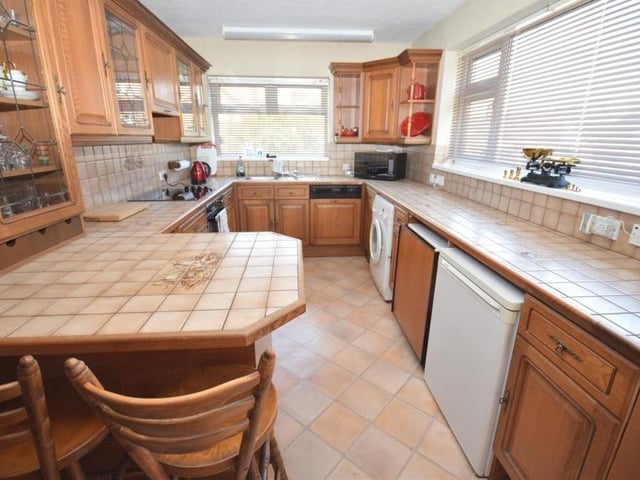 Let's begin our brief tour of the Ravenshead property in the breakfast kitchen. A bright and sunny space, it features base and wall units with tiled worktops, an inset stainless steel sink and drainer, and a breakfast bar for informal dining.