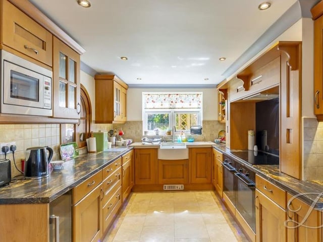 The spotless kitchen includes a wonderful range of matching units and cabinets with worktops over. Integrated appliances include a double oven, induction hob with extractor fan above, wine cooler and microwave, while there is space for a double fridge/freezer. Downlights and a Belfast sink with mixer tap add to the room's appeal.