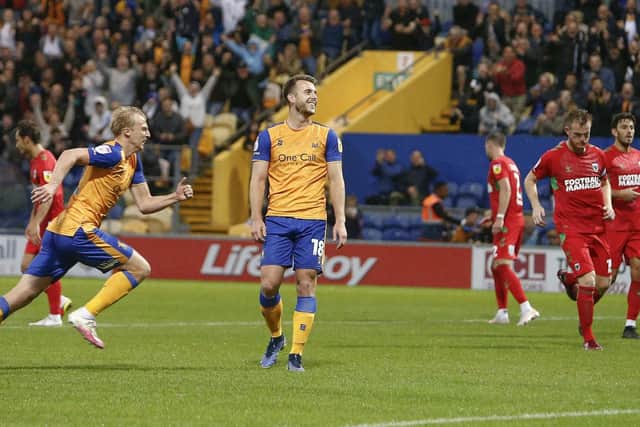 Mansfield Town forward Rhys Oates celebrates his goal against AFC Wimbledon before going off injured.