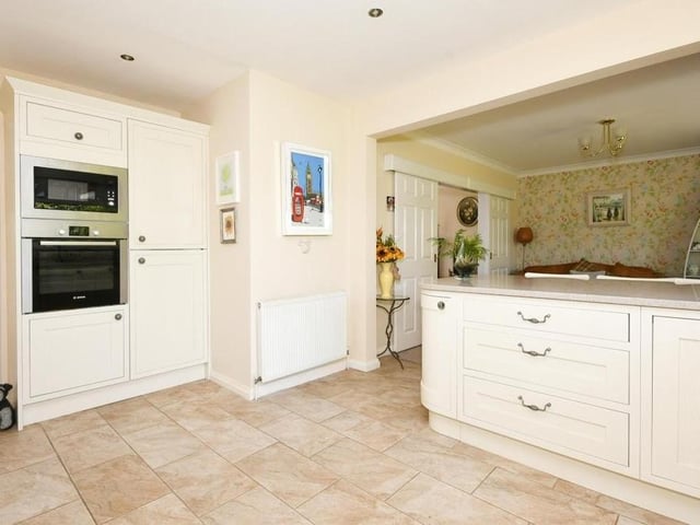 The kitchen at the £450,000 bungalow is modern and squeaky-clean, featuring matching wall and base units, granite worktops, one-and-a-half sink, breakfast bar and tiled flooring.