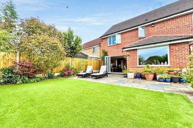 Outside, the enclosed rear garden features a lush lawn area
