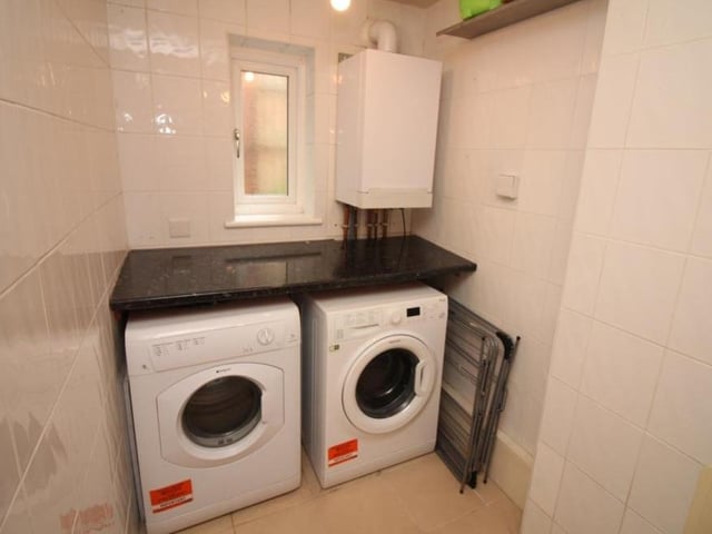 This handy utility room can be found next to the kitchen. It has a wall-mounted Viessman combination boiler and tiled flooring, plus space and plumbing for a washing machine.