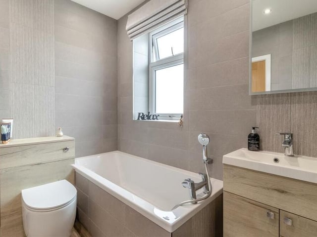 The family  bathroom is one of the recent, modern additions to the £395,000 Forest Town property. A four-piece white suite with chrome fittings, it includes a bath tub with mixer tap and shower attachment,  a low-flush WC and a wall-hung vanity unit with inset wash hand basin, mixer tap and storage cupboard beneath.