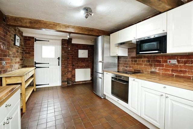 The kitchen is an alluring mix of contemporary, integrated appliances and exposed brickwork and ceiling beams. There is also an original stable door that leads to the garden.