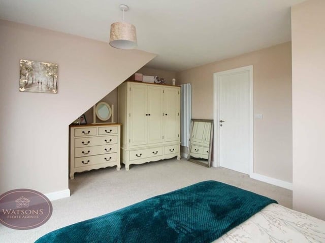 There is plenty of space in the attractive primary bedroom for wardrobes and a dressing table.