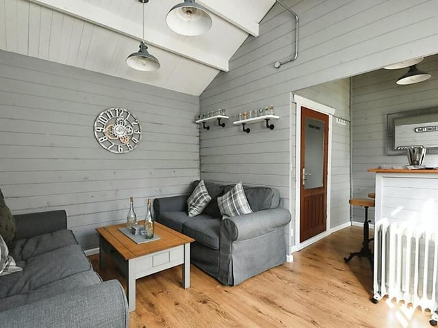 Inside the summer house is this stylish bar area, complete with cosy seating, power and lighting.