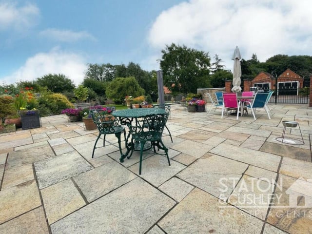 This large patio and seating area is a lovely spot for relaxing in the sunshine or entertaining family and friends.