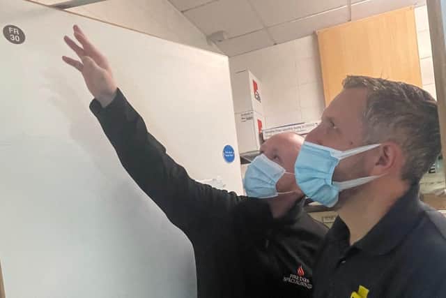FDS project manager Anthony Beech, left, with Dave Martin from Ideal Cleaning Services inspect a a fire door.