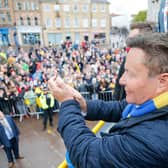John Radford salutes fans on the promotion open top bus parade. Photo by Chris & Jeanette Holloway/The Bigger Picture.media