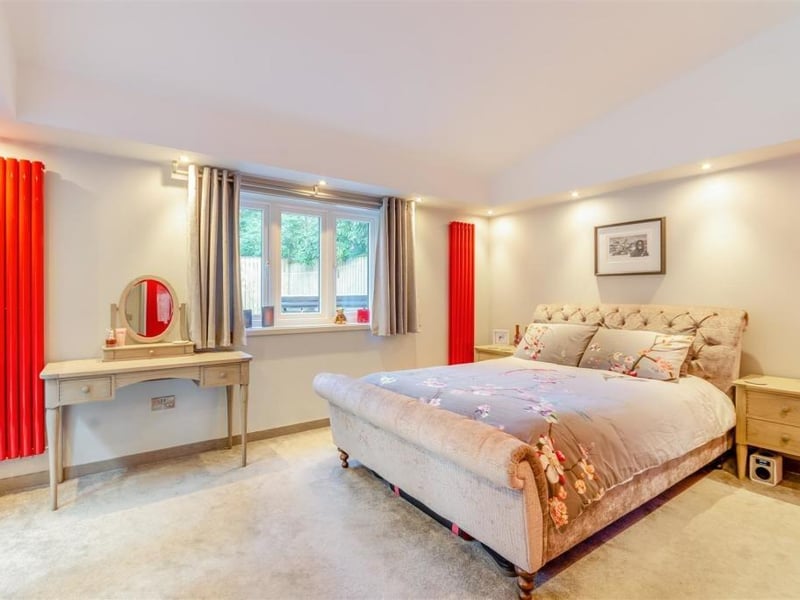 This is our first look at the master bedroom, which is a large, dual-aspect suite, facing the side and back of the property. Ceiling spotlights are attached to all four sides of the room, adding to its natural brightness..