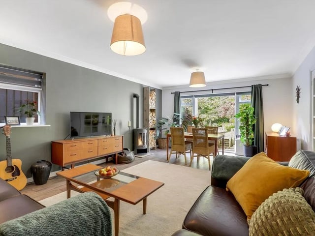 The lounge/diner enjoys an abundance of natural light thanks to French doors opening out onto the patio, creating a seamless connection to the beautifully landscaped garden.