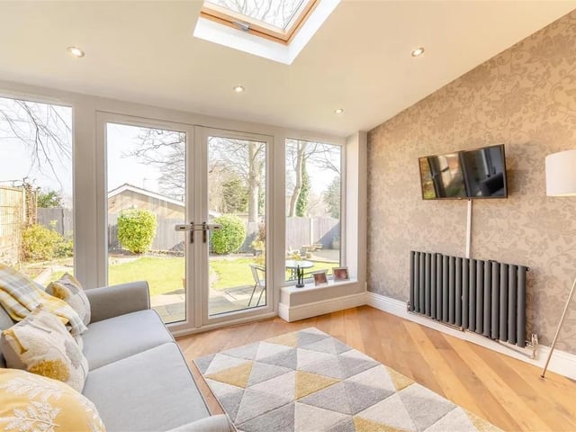 A lovely, light and airy living space with sloping vaulted ceiling, oak floor, radiator, velux roof window, eight ceiling spotlights, radiator, two floor to ceiling windowpanes either side of French doors leading out onto the rear garden.