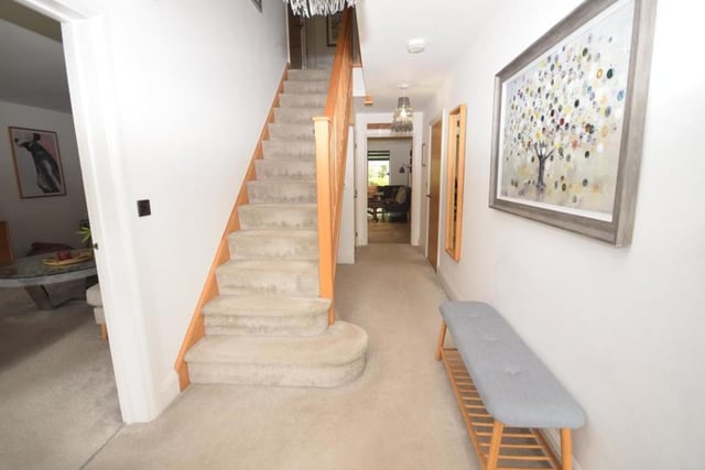As we prepare to go upstairs, we move into the warm and welcoming reception hallway. Underneath the staircase is a storage cupboard that houses the property's CCTV and underfloor heating systems.