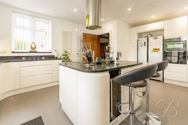 A wine cooler is one of the eyecatching features of the modern kitchen, which also boasts a range of integrated appliances, including oven, microwave and dishwasher. Downlights and under-cabinet lighting add to the brightness provided by triple-aspect windows.