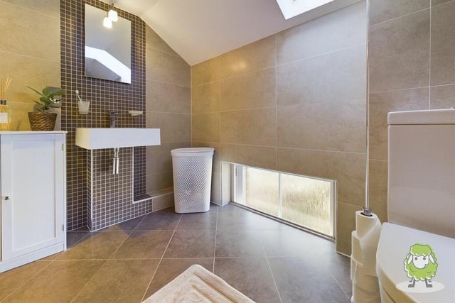 The master bedroom boasts a sleek en suite wet room with shower and wash hand basin.